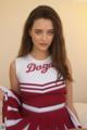 A woman in a red and white cheerleading uniform posing for a picture.